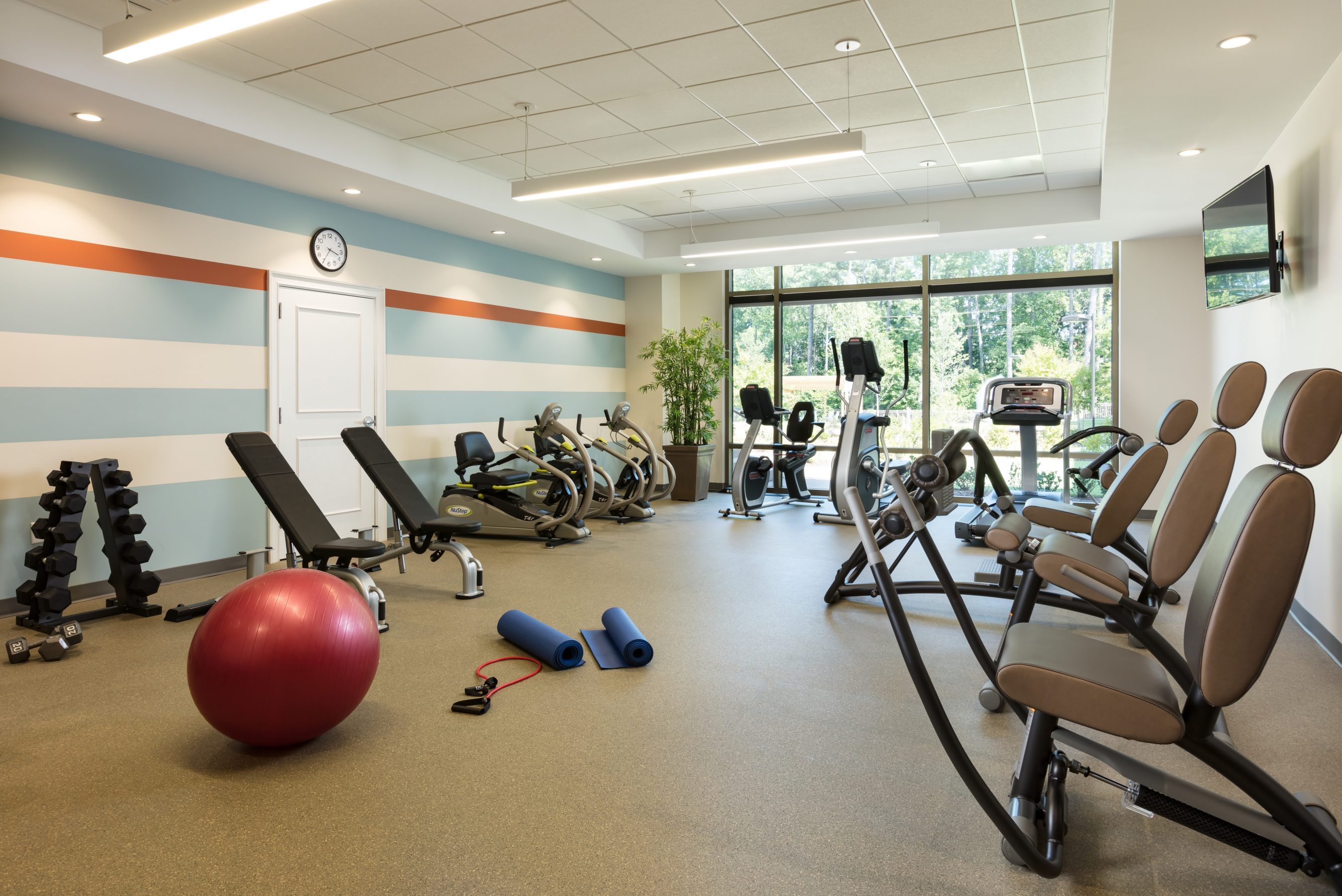 Fitness room at The Cardinal featuring weights, machines, and other workout equipment.