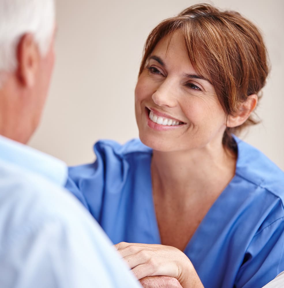 Young female nurse smiling up at an older man.